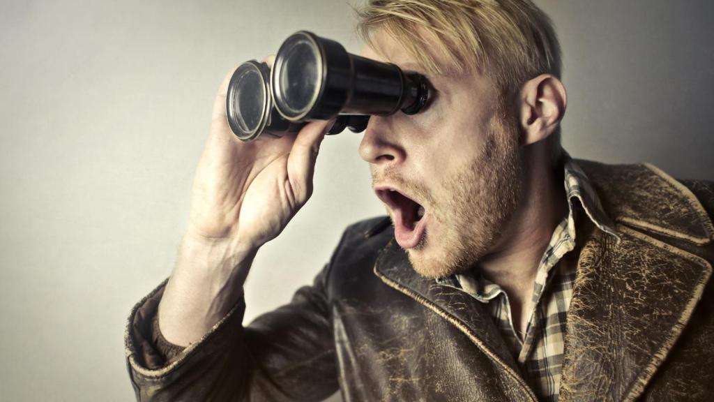 person spying through binoculars