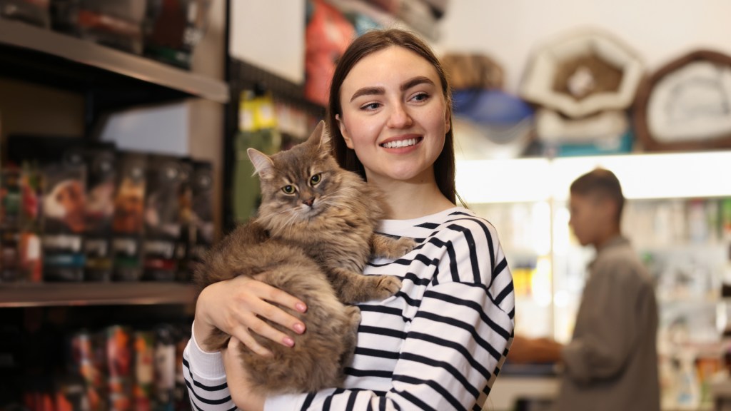 A woman holding a cat in a pet store