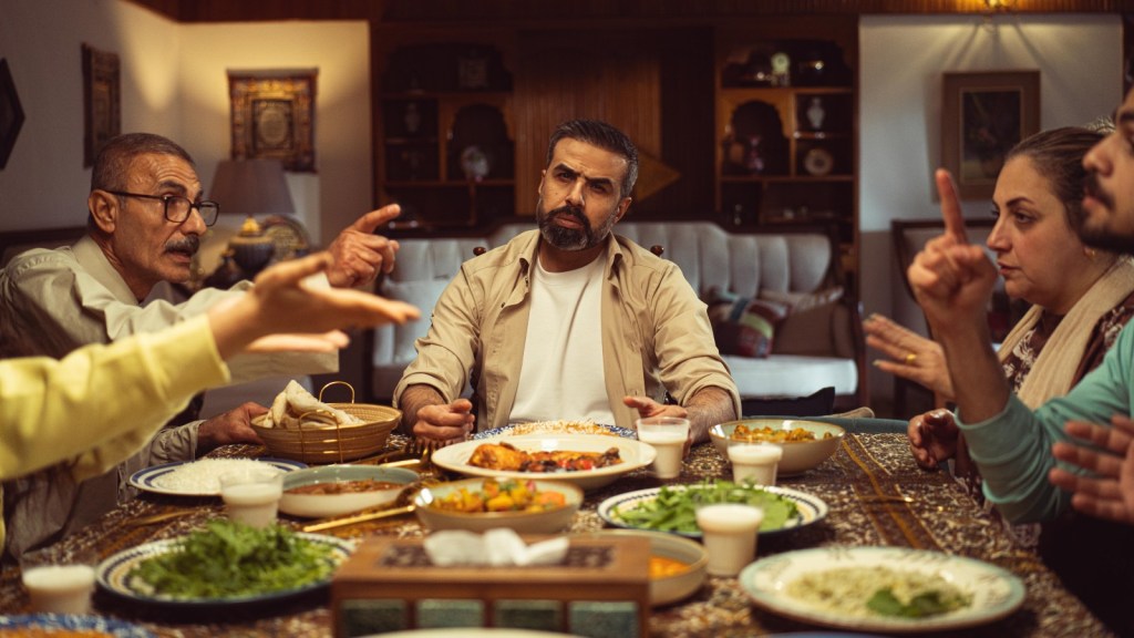 a man sitting with his family who are arguing