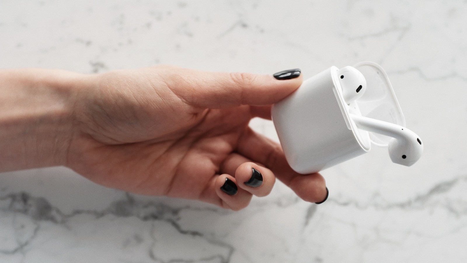 She Trusted Her Boyfriend With Her Most Valuable Possession—Then He Showed Her She’d Made a Terrible Mistake a woman's hand holding AirPods