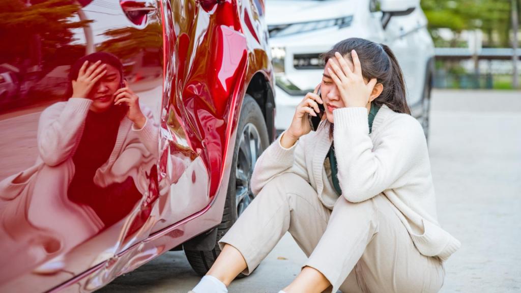 woman on the ground next to a car