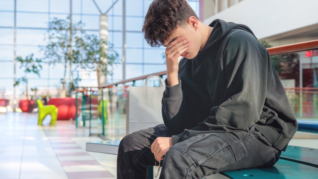 sad teen boy sitting on bench