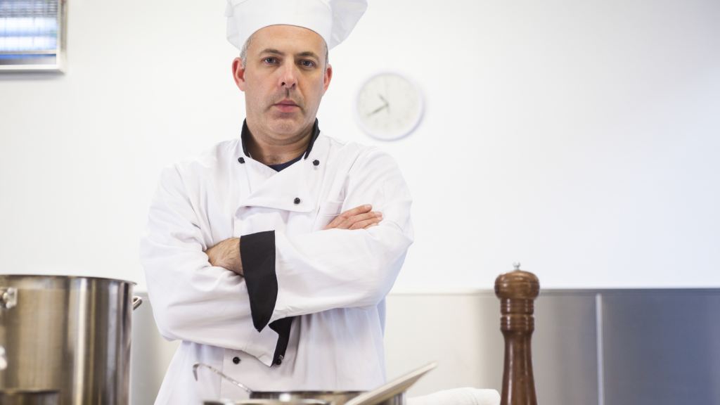 A Waiter Demanded a Meal From a Cook With an Attitude—Then Quickly Learned Why Respect Matters in the Kitchen serious chef folding arms looking concerned in kitchen