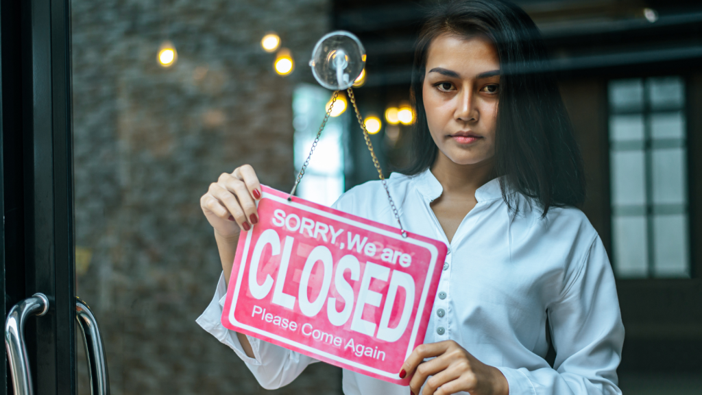 shopkeeper blankly showing store is closed