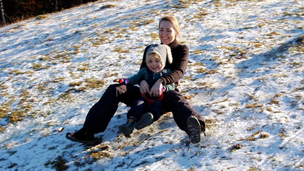 woman sledding with her son