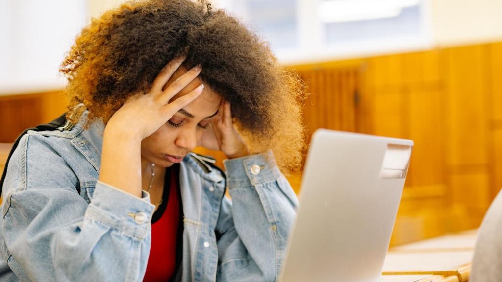 stressed college student with hands over head