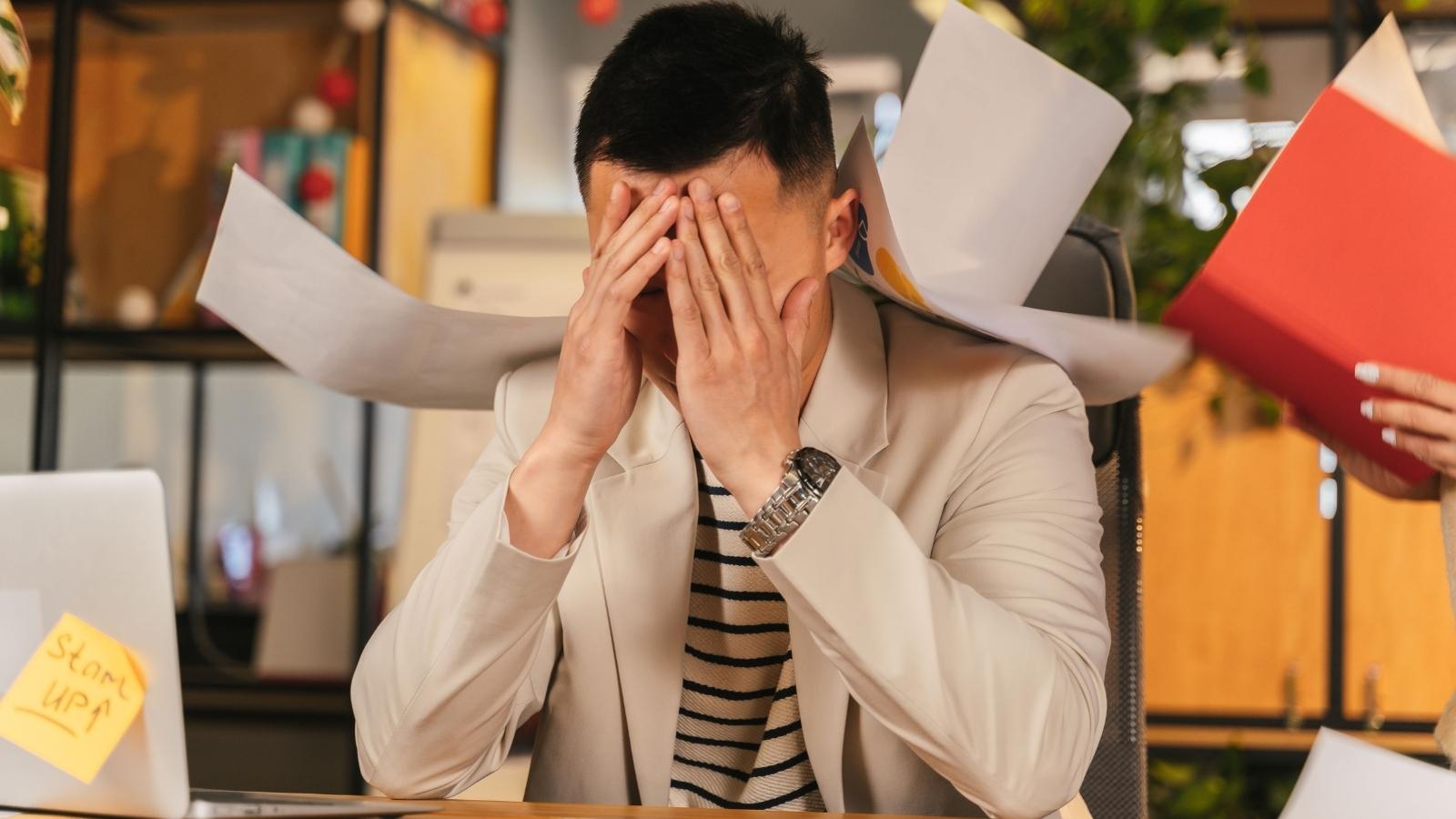 After 8 Months of Flawless Work, Boss Publicly Shames New Developer and Tells Him to Leave the Industry stressed man buried in work