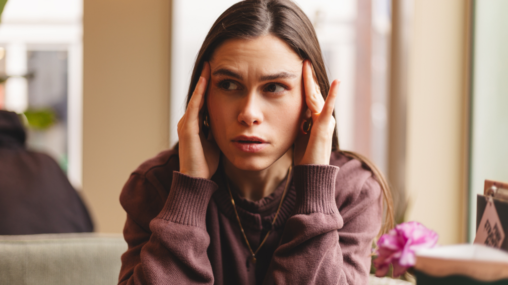 stressed young woman with hands on temples