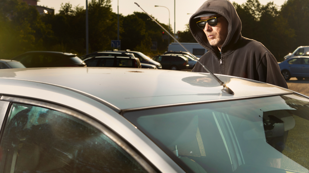 One Employer Thought Taking Back A Company Vehicle Would Be Simple, Until The Fired Worker Forced Him Into An Unexpected Retrieval Mission suspicious man standing by car wearing a hoodie and sunglasses