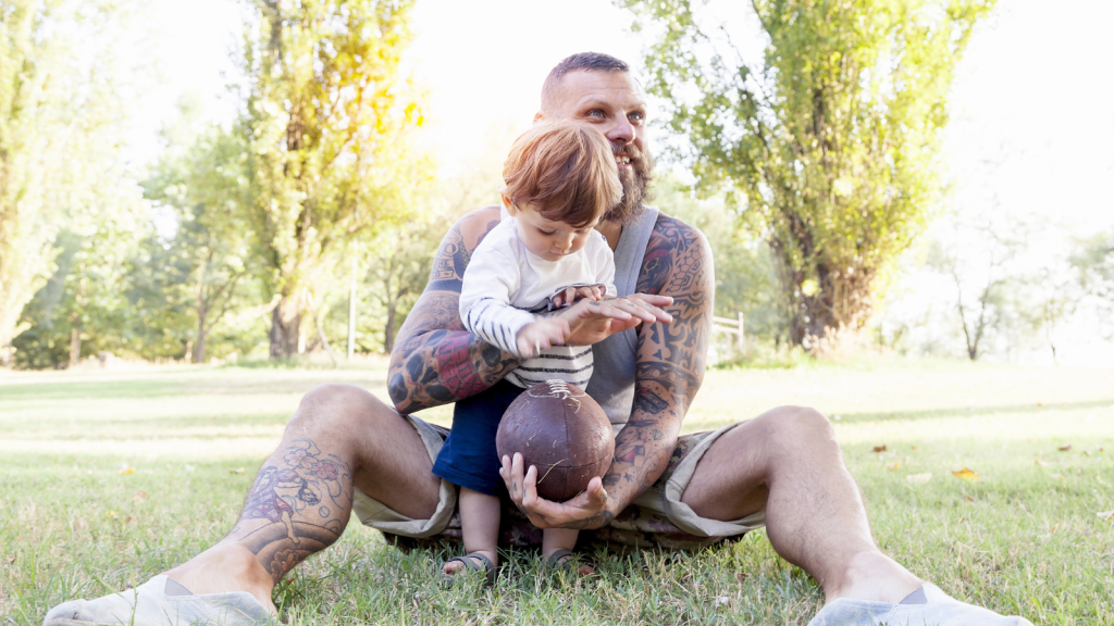 tattooed dad playing with child