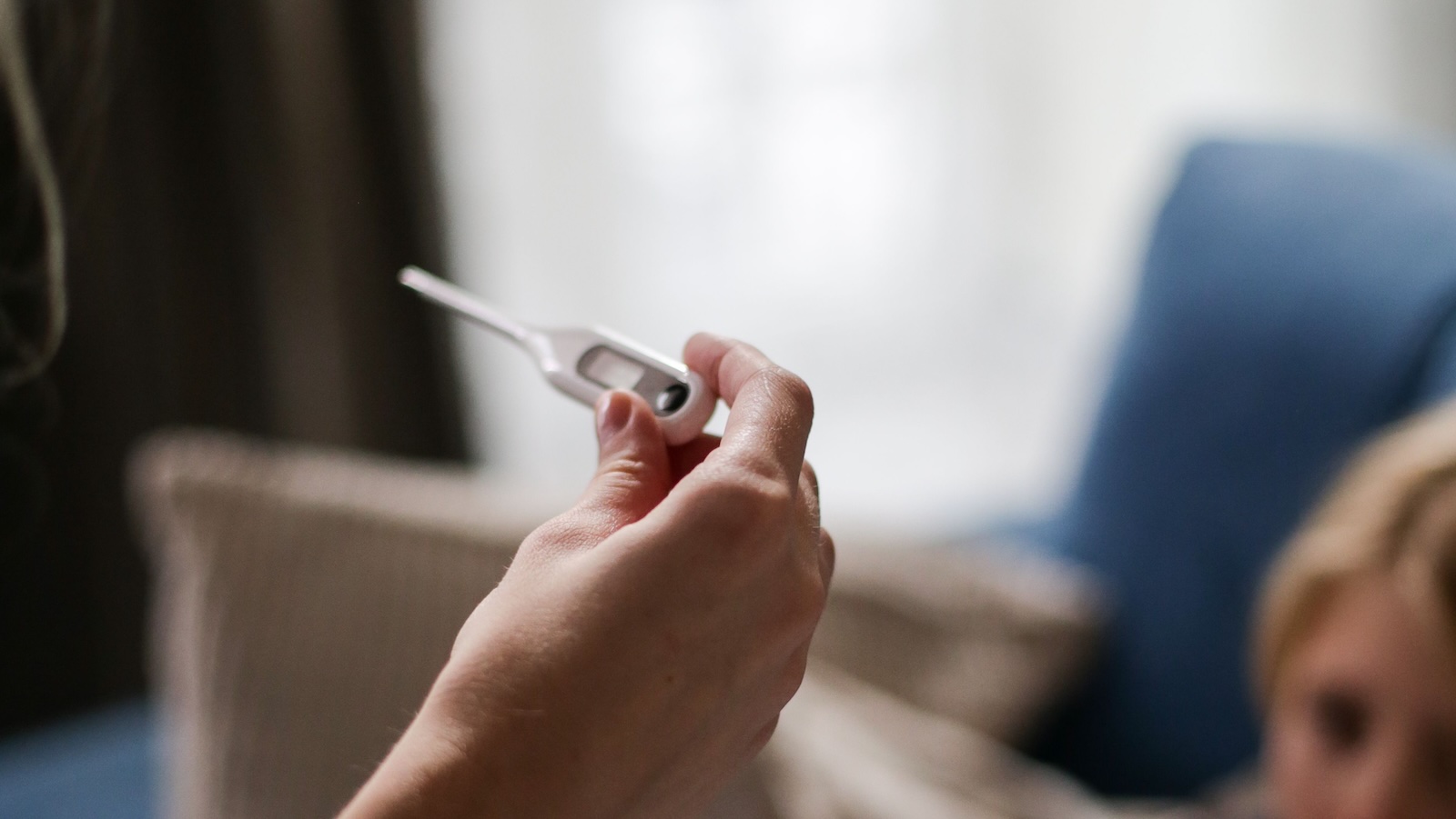 person holding a thermometer with fever/sick people