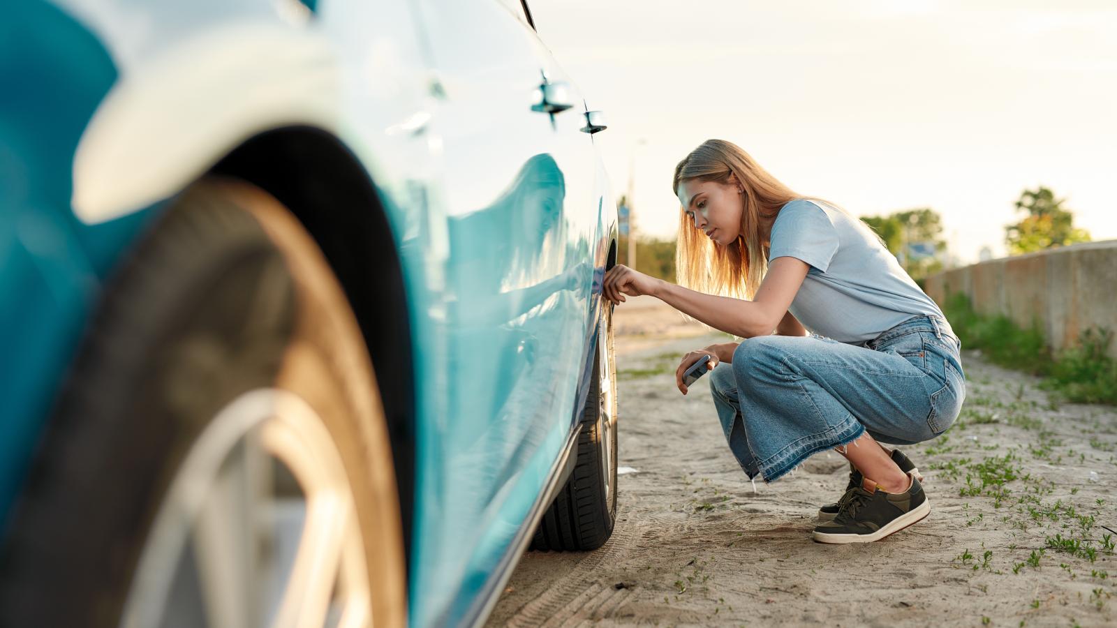 woman looking at her car tire