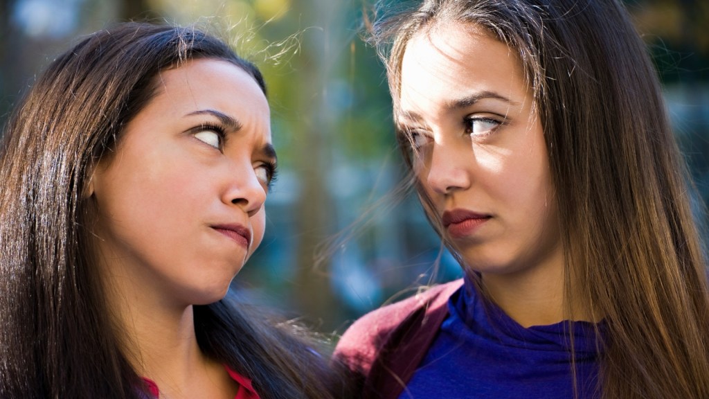 two sisters looking at each other with concern