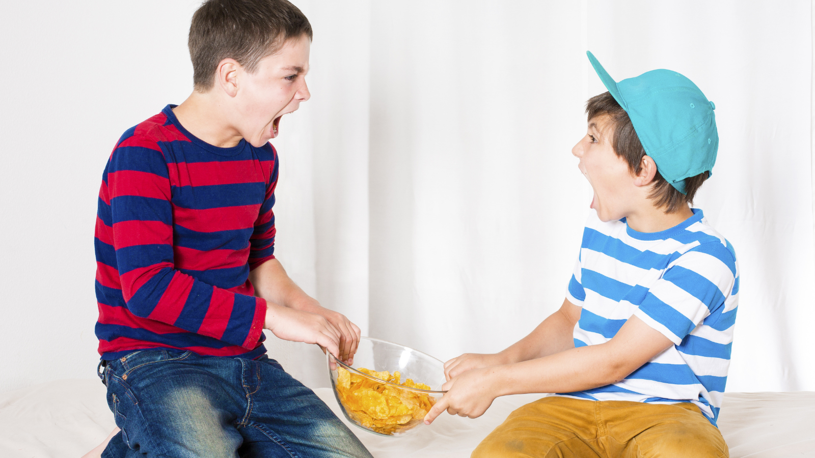 A Blended Family Conflict Has One Dad Questioning His Relationship After His Son Struggles To Get Along With His Girlfriend’s Child two young boys fighting over bowl of snacks