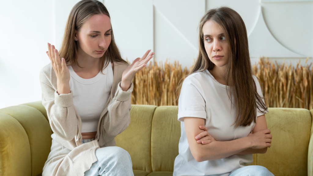 two young women arguing on the couch
