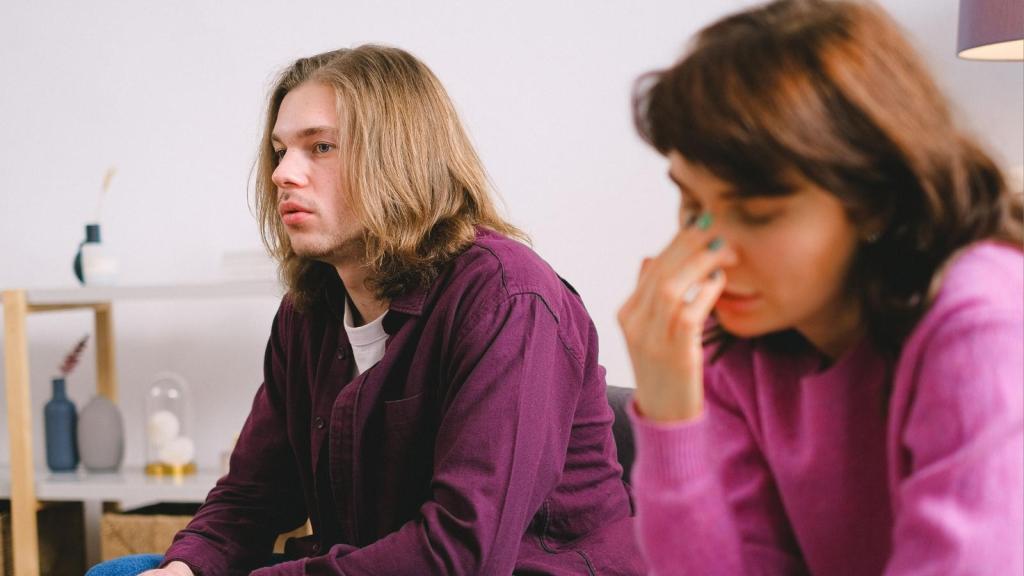 upset couple sitting next to each other on couch