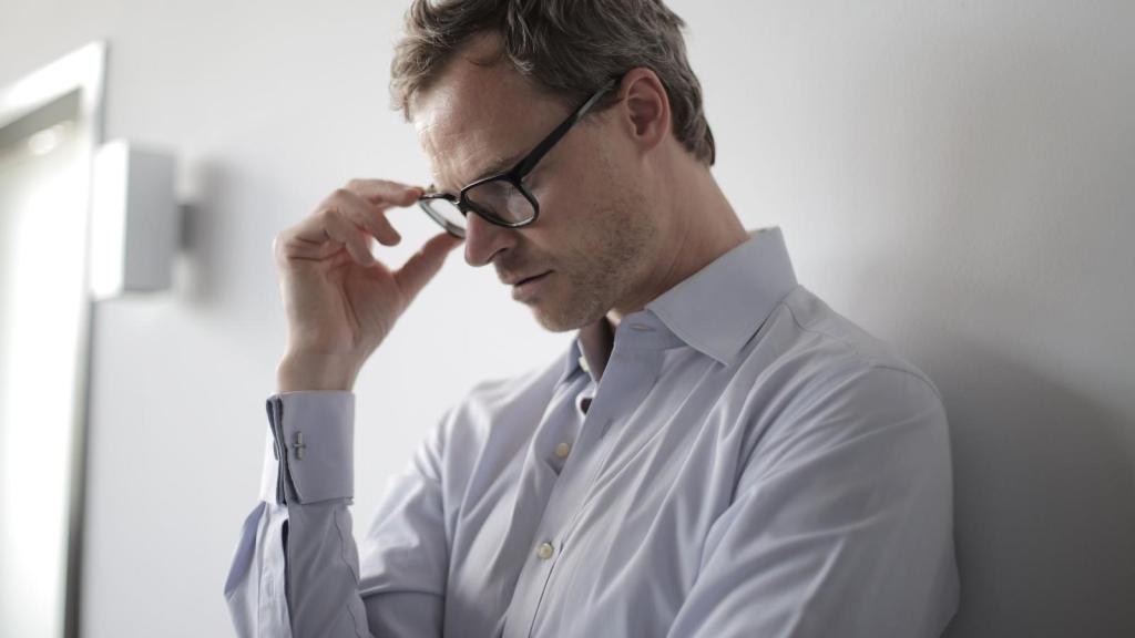 upset man leaning against the wall