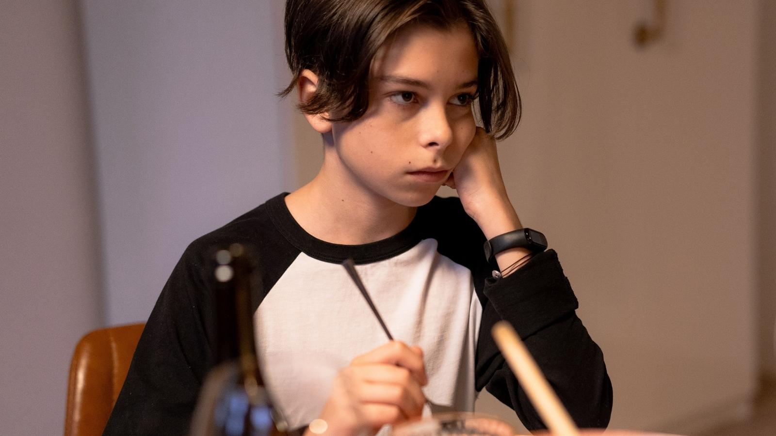 upset teenage boy at the dinner table