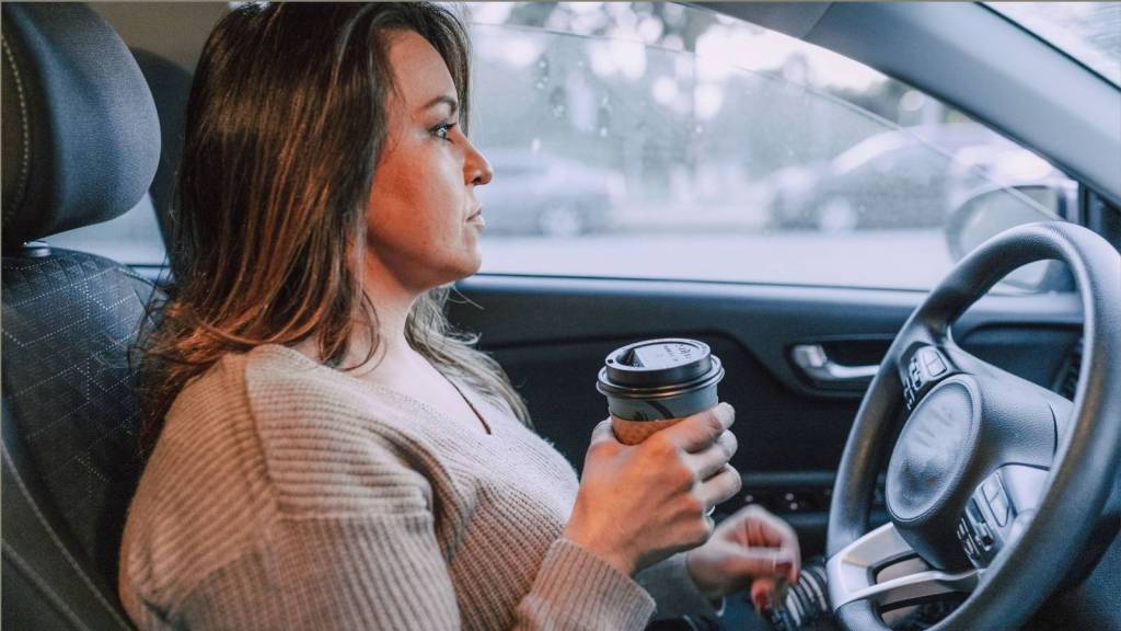 woman drinking coffee in car