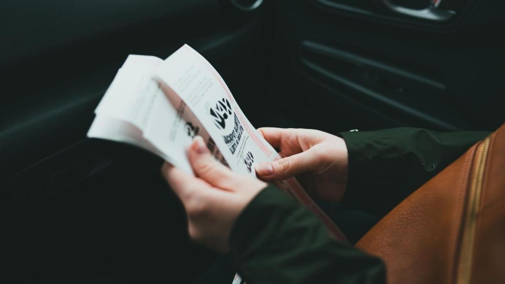 woman holding two concert tickets