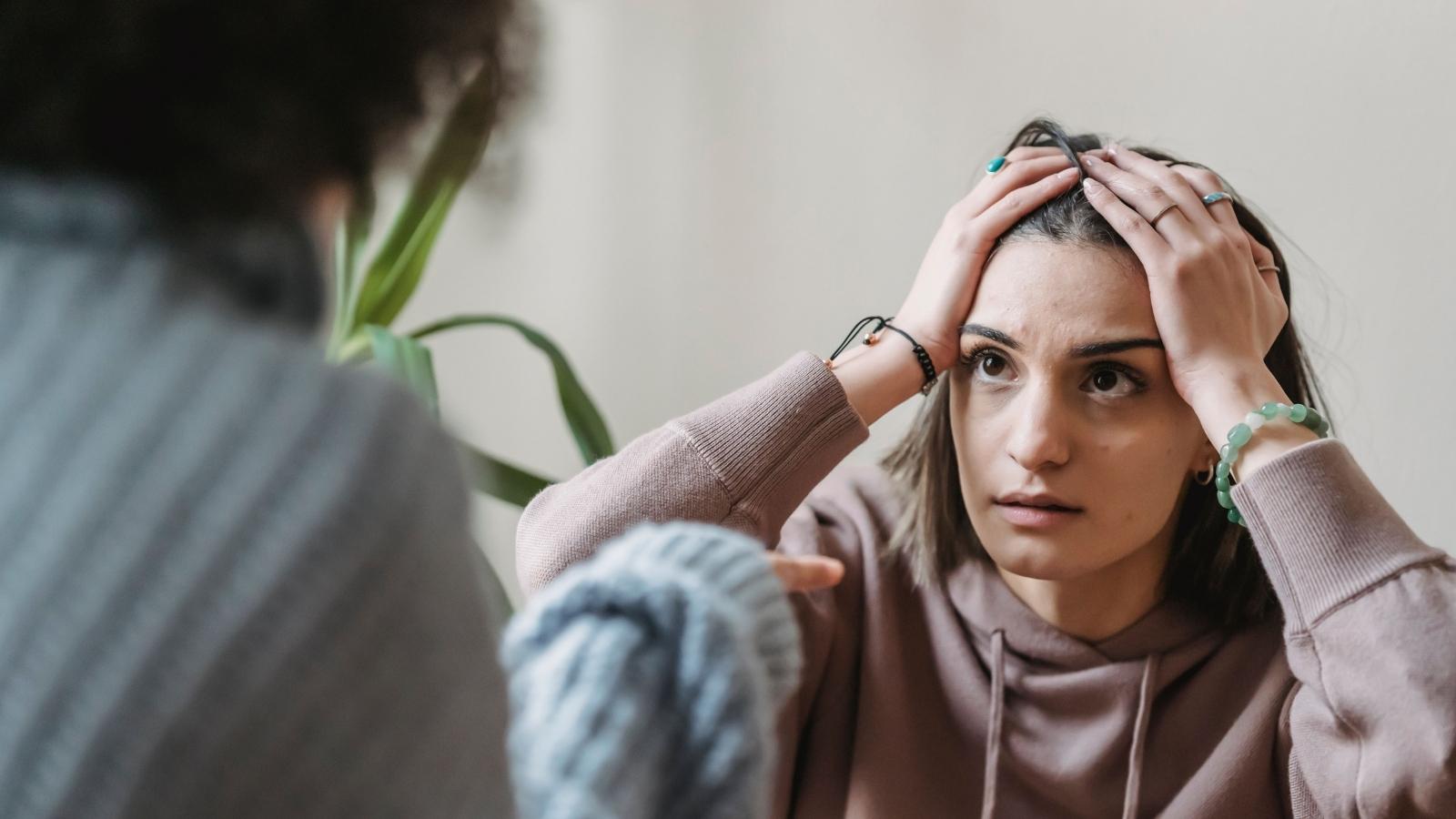 She Stopped Reminding Her Forgetful Friend About Plans. She Got Called Petty When They Missed One. woman in beige hoodie looking distressed
