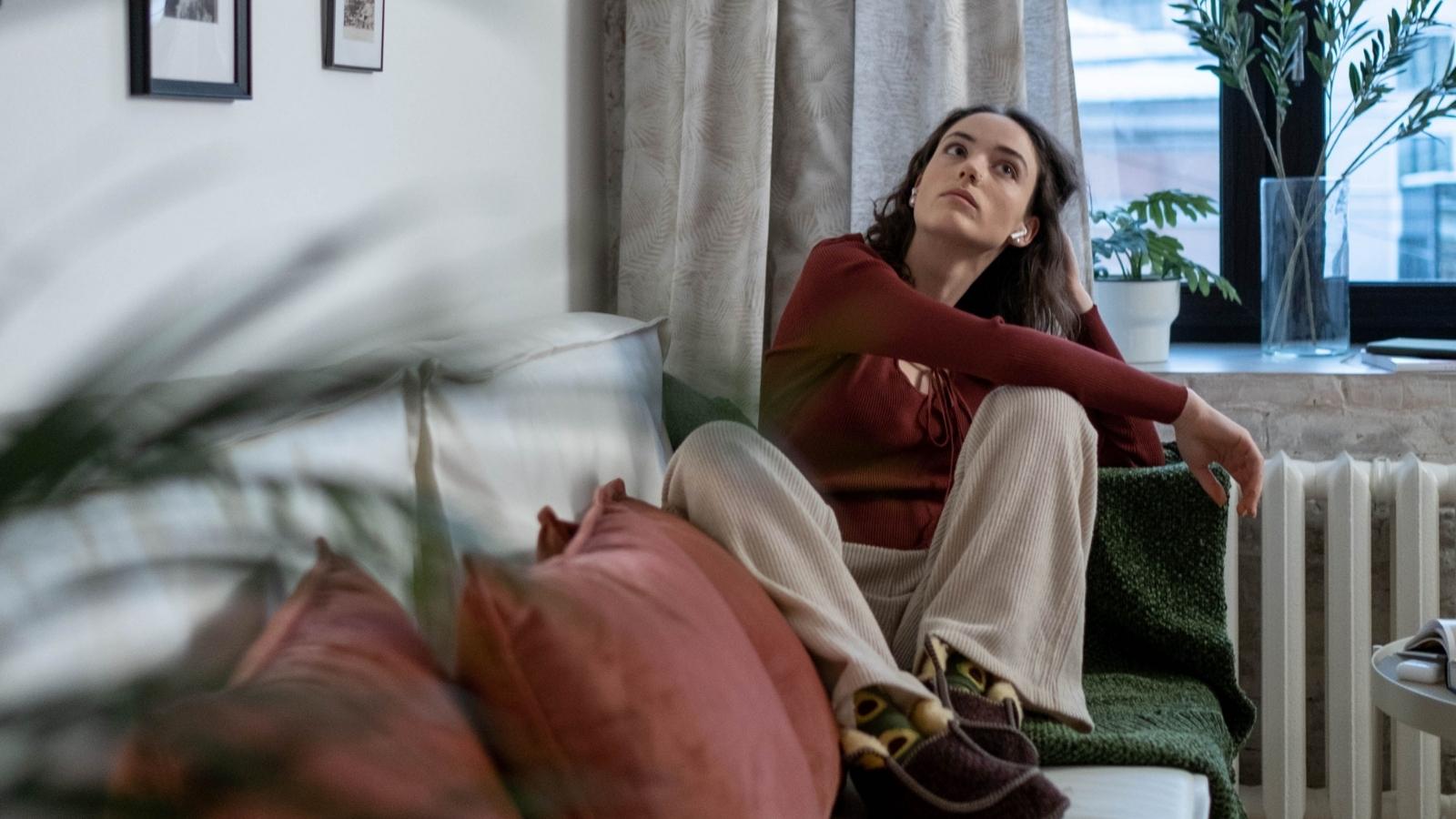 She Thought Her Family Was Calling to Apologize—Then Realized They Only Wanted Dog Pictures woman looking bored on the couch
