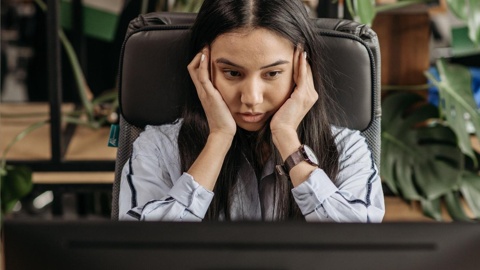 Her Boss Used Her Facebook Photo for Weekly AI Posters—But She’s Not Sure If She Should Report Him to HR woman looking stressed at her computer