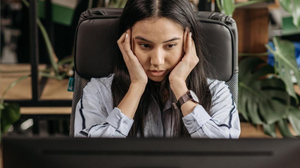 woman looking stressed at her computer