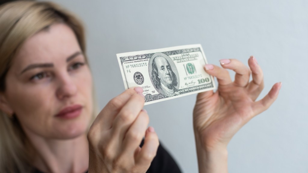 woman studying counterfeit bills