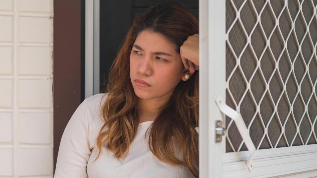 woman looking out her front door