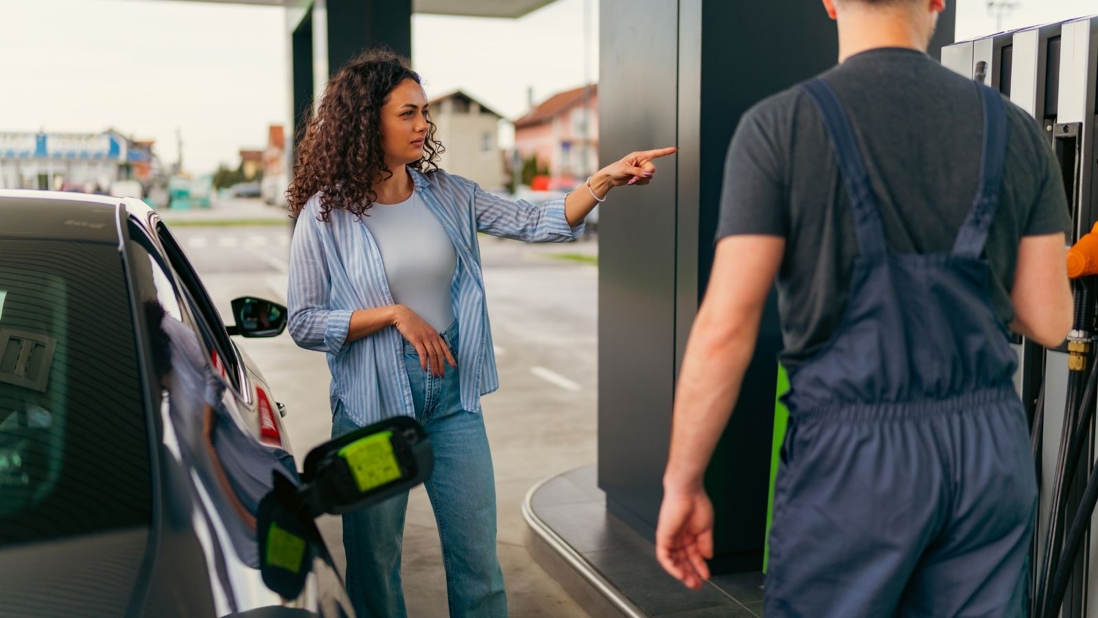 woman pointing another gas station customer inside