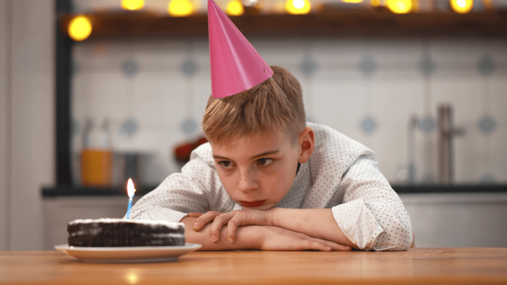 young boy sad alone at birthday party