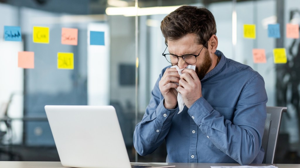 young man sick working at the office