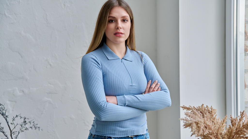young woman folding arms looking at camera