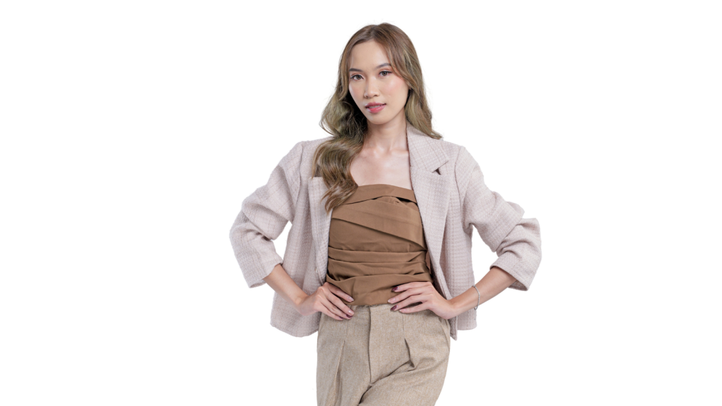 young woman in tan jacket with hands on her hips