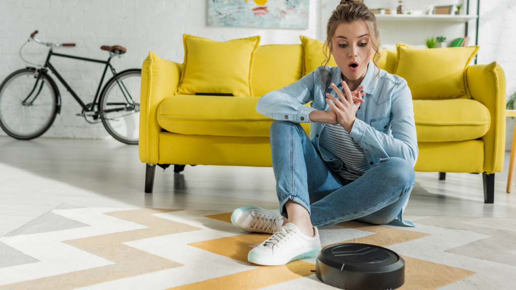 young woman looking at roomba in her apartment