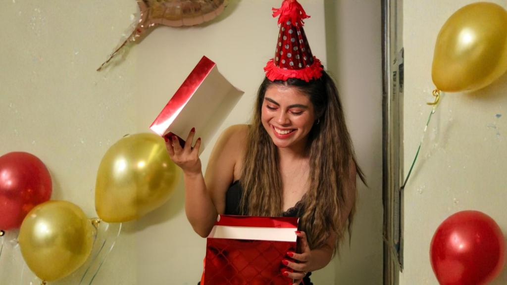 young woman opening a birthday gift