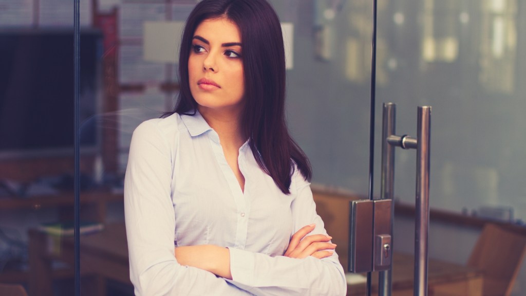 young woman outside corporate office frowning