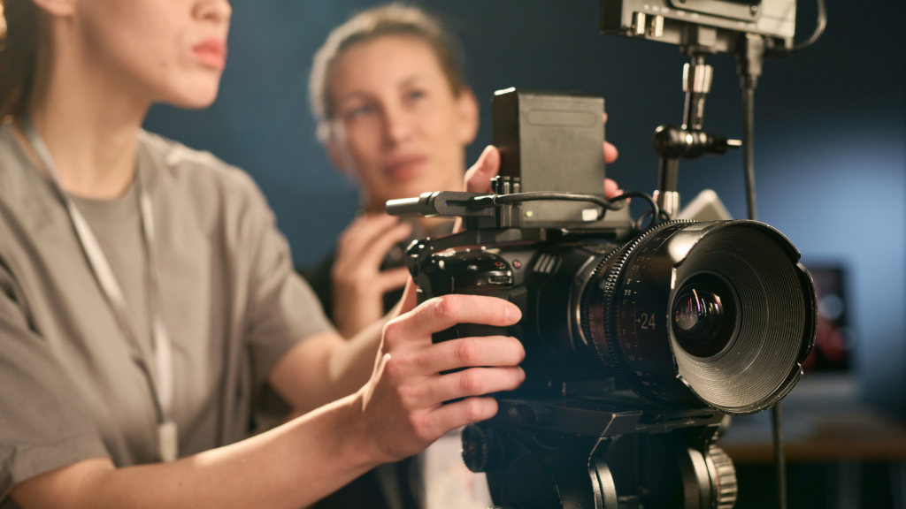 young woman videographer behind camera