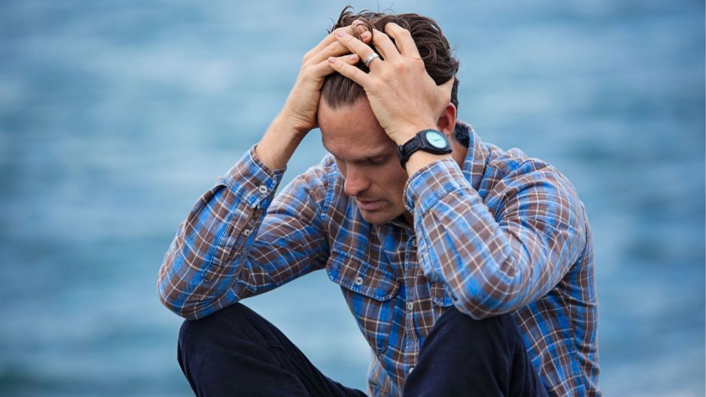 Sad man sitting by the sea