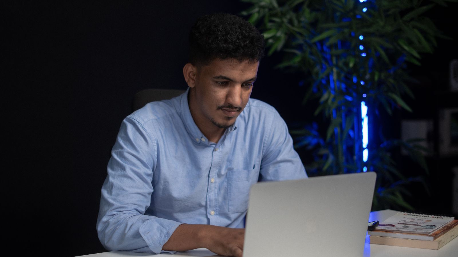 A Company Rolled Out A New Billing System And Quietly Cut Employees Pay, Now Workers Are Furious Over The Sudden Change Man in blue shirt working on his laptop