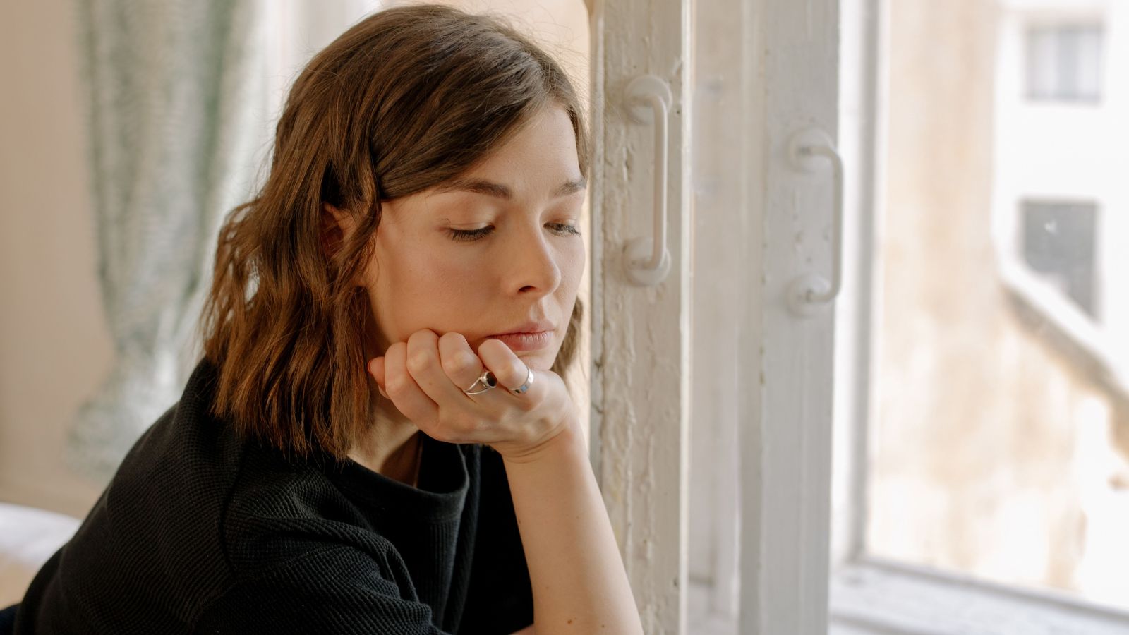 Aunt Tried To Fix Problems Between Her Niece And Brother In Law, But Things Got Worse And Now She Wonders If Its Her Fault Sad woman sitting by the window