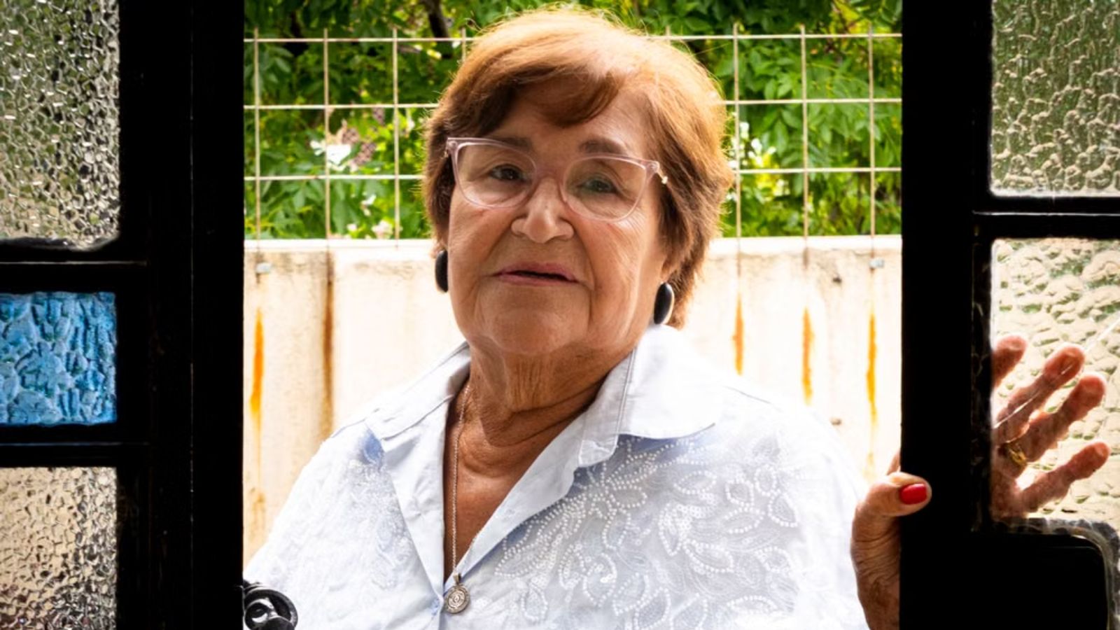 A Yearlong Feud With Her Infuriating Neighbor Escalated Until a Judge Stepped In With an Immediate No Contact Order An elderly lady looking through an open window