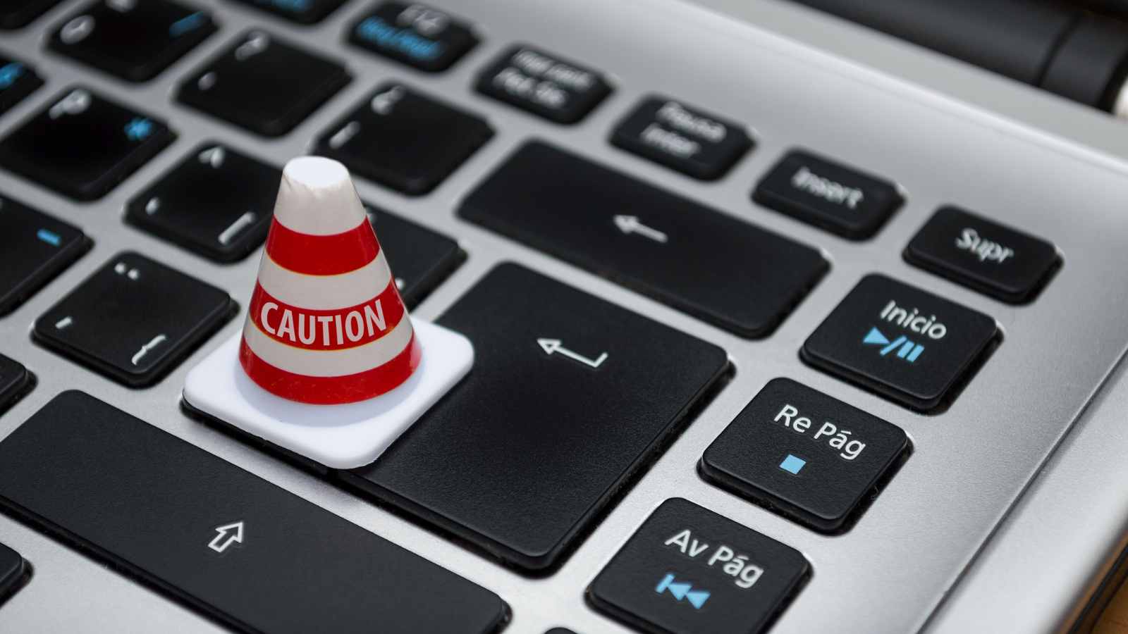 A tiny traffic cone on a laptop keyboard