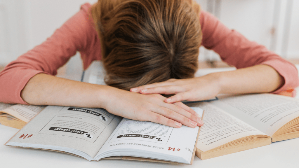 A student asleep on a textbook