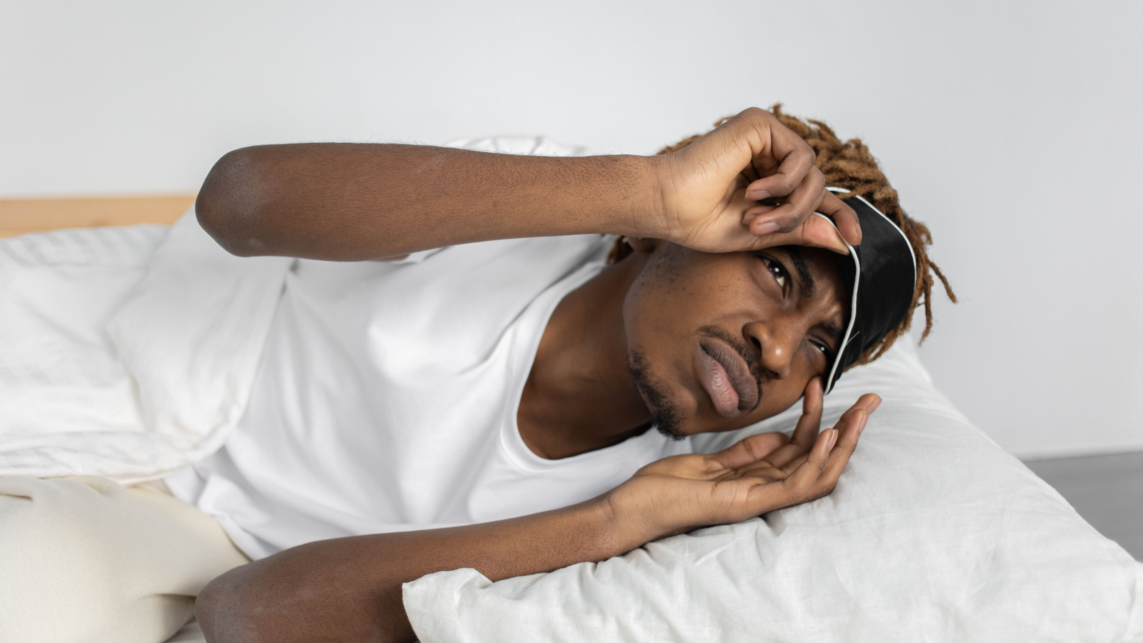A man peeking out of his sleep mask