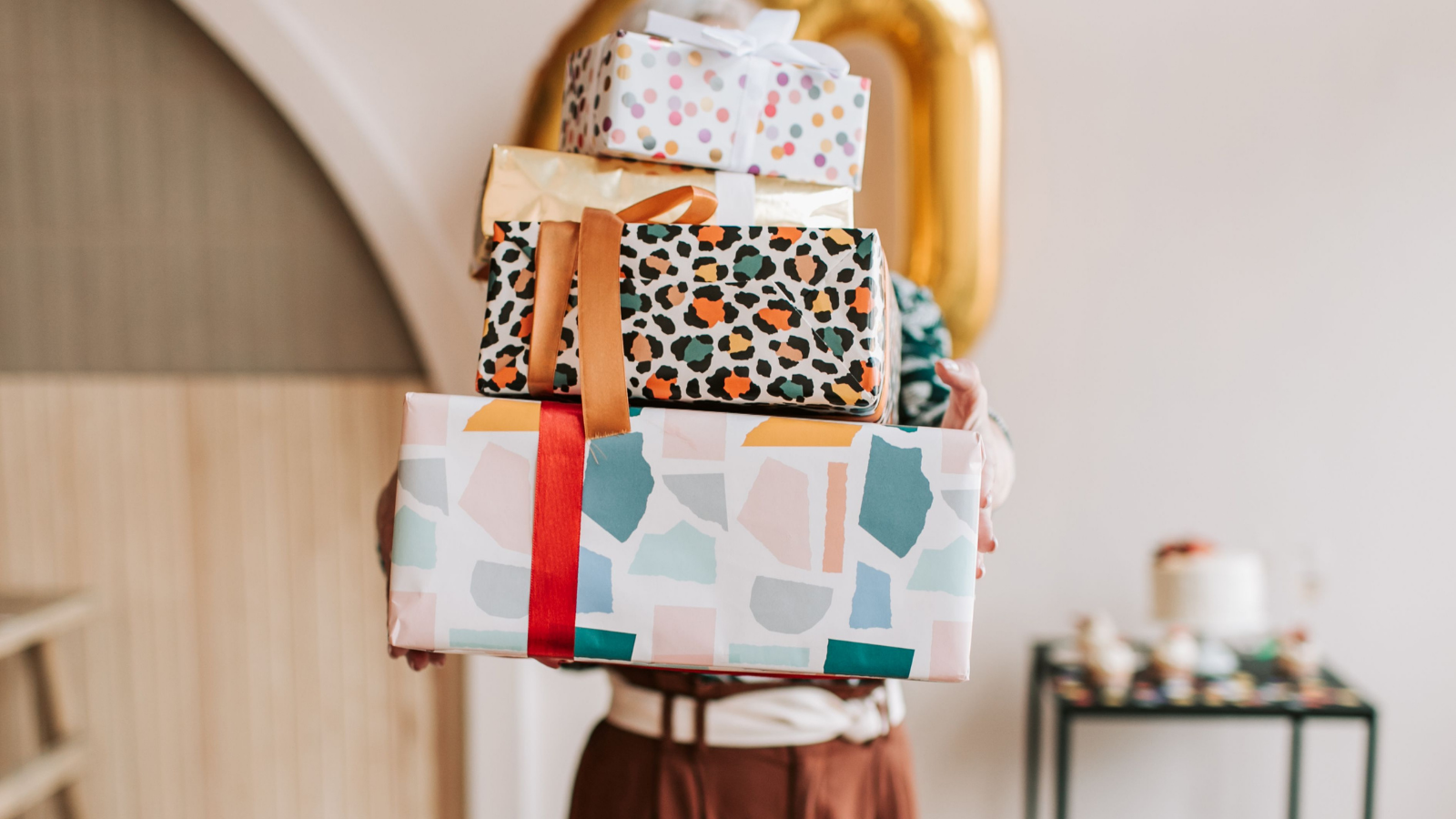 She Demanded He Return His Sister’s Custom Birthday Gift for Being Inappropriate—Then Got Publicly Exposed in Front of the Whole Family A person carrying a stack of presents