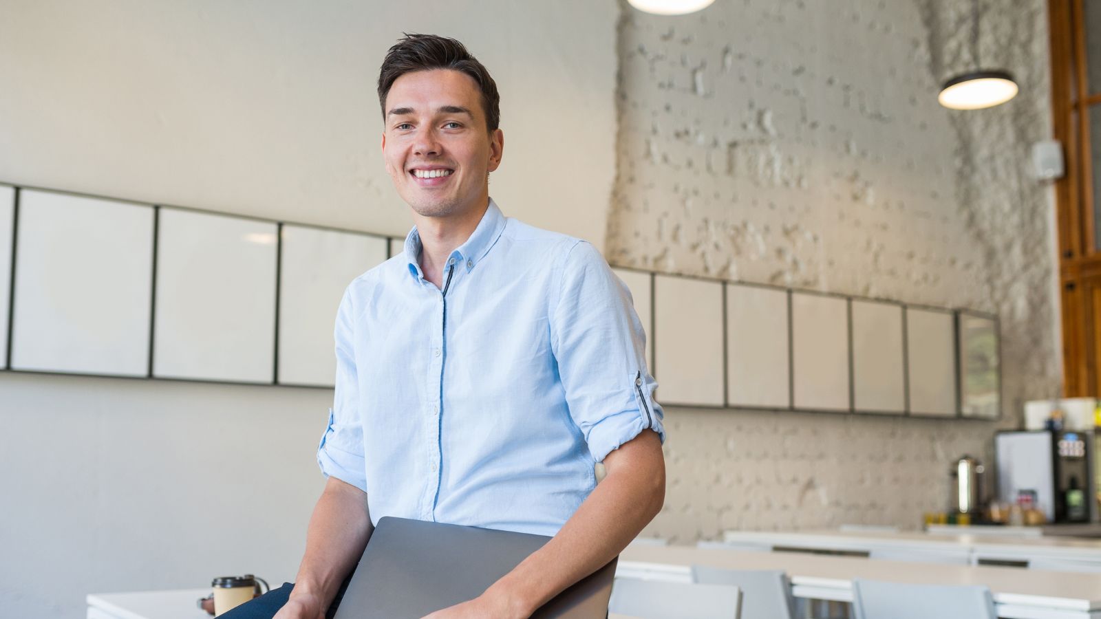 An Employee Watched His Lazy Coworkers Crush Their Workload and Land High Paying New Jobs—While He Worked Twice as Hard and Got Stuck Male employee casually sitting on the table while holding his laptop