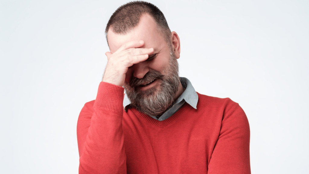 He Tried to Discreetly Buy a Sensitive Medical Item—Then Realized His Chatty Cousin Was Ringing Him Up Man covering his eyes after making an embarrassing purchase