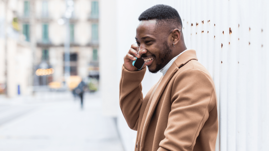 Man in brown coat on a street talking on call